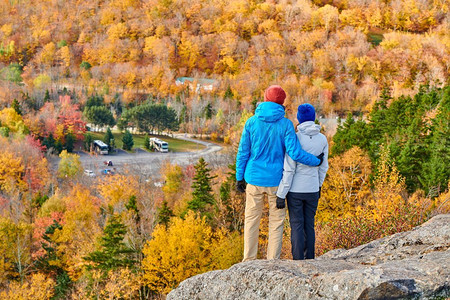 一对情侣秋天在艺术家S悬崖徒步旅行。弗朗科尼亚诺奇州立公园的秋色。白山国家森林，美国新罕布夏州