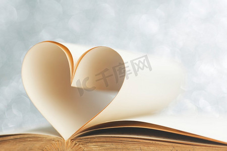 书以打开的书页和形状的心爱的阅读观念。书与书页形状的心