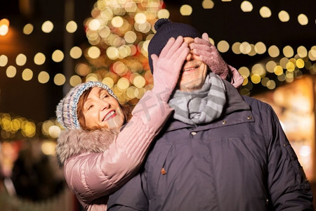 爱情、寒假和圣诞集市上的人们概念快乐的老夫妇。圣诞集市上快乐的高年级夫妇