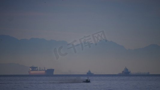大海上的货船摄影照片_直布罗陀海峡上货柜工业船的海景。物流运输概念..海上有货船，直布罗陀海峡