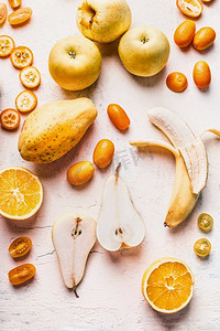 各种黄色和橙色的水果平躺在白色的桌子上，顶视图.健康食品。