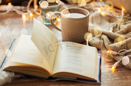 Hygge和舒适的家庭概念书和一杯咖啡或热巧克力在桌子上。桌上有一本书和一杯咖啡或热巧克力