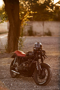 摩托车背景摄影照片_带头盔的旧摩托车户外