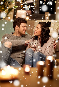 海报详情天猫淘宝摄影照片_宠物，圣诞节和人们的概念幸福的夫妇在家里的猫在雪地上。家里养着猫的幸福夫妻