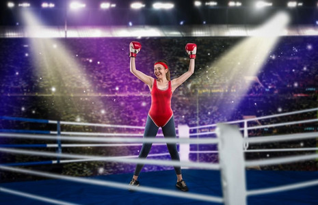 女拳击手摄影照片_女拳击手在红色绷带和运动服的手在环，侧视图。拳击台上的女人。女拳击手在红色运动服手在戒指