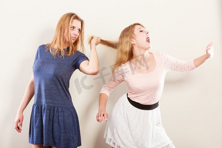 好斗的疯女人互相打架扯头发。两个年轻的女孩在打斗中挣扎。暴力..疯狂的女人互相打架。