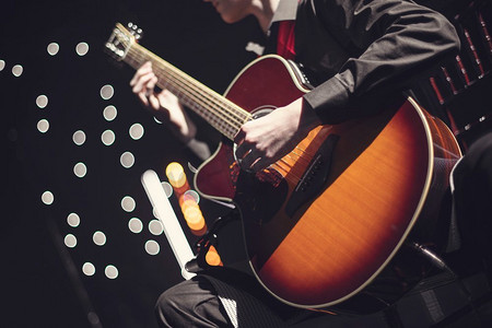 一位吉他手在音乐会上演奏和唱歌