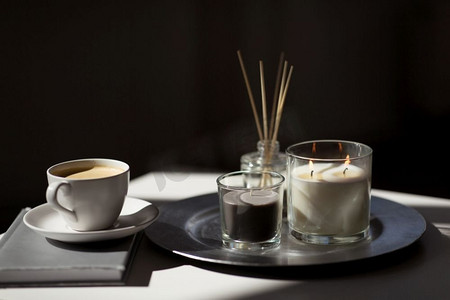 水疗和芳香疗法的概念-咖啡、蜡烛、书籍和桌子上的香草扩散器。桌子上有咖啡、蜡烛和香料扩散器