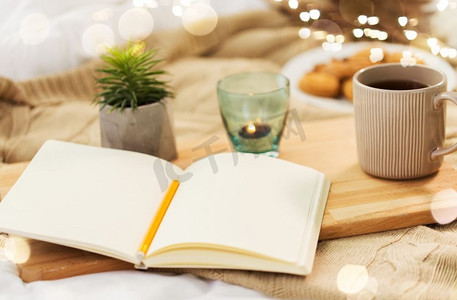 Hygge和灵感概念—日记，茶和蜡烛在家里持有人。日记、茶和蜡烛在家里