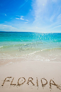 绿松石的水和金色的沙子与“佛罗里达”写在它。佛罗里达字在海滩上