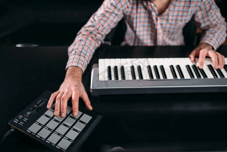 男音响工程师手在音乐键盘，特写。数字录音技术。媒体工程
