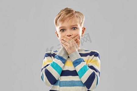 表情和人的概念 — 穿着条纹套头衫的小男孩在灰色背景下用手闭上嘴巴