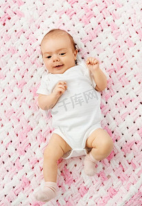 婴儿时代和人的概念—甜蜜的小女婴躺在编织粉红色毯子毛绒纱。甜蜜的女婴躺在编织毛绒毯子