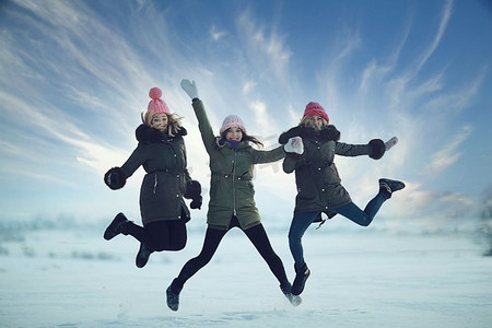 冬天的年轻女子在雪地里散步和玩耍