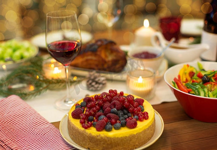 圣诞晚餐和吃的概念--在家里的餐桌上摆上浆果蛋糕和其他食物。蛋糕和其他食物放在家里的圣诞餐桌上