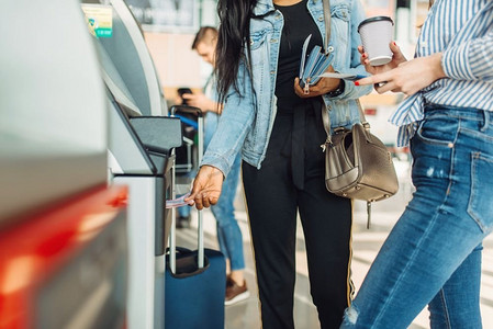 带着行李的游客在机场的自动取款机上取现金。旅客带行李在机场航站楼，愉快的旅程，夏季旅行假期