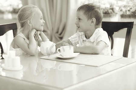 儿童餐厅摄影照片_男孩和女孩一个甜点在咖啡馆爱