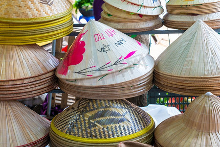 比心文字动效摄影照片_手工制作的传统越南叶帽出售在市场会安，越南，亚洲，装饰有英文和越南语的文字越南。