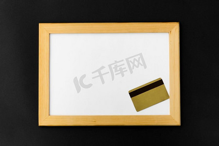 消费卡劵摄影照片_购物和消费主义概念—白色磁性板和信用卡在黑色背景。白色磁性板和信用卡在黑色