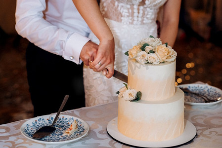 金色婚礼装饰摄影照片_婚礼装饰，在瀑布的背景下，蛋糕放在木凳上