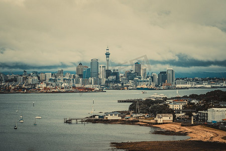 奥克兰城市天际线，新西兰，与钓鱼码头，市中心和奥克兰天空塔多云。老式彩色滤光片。