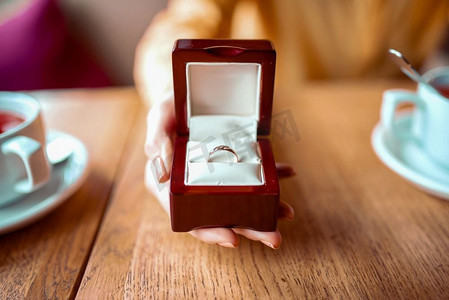 女性人手握盒与黄金结婚戒指特写视图