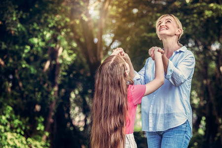 放松快乐的母亲和小孩子女儿在户外公园。父母和儿童观念。