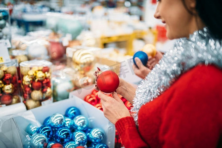 女性在超市买圣诞树球，这是家族传统。12月份假日购物
