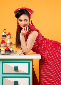 爱心义卖海报素材摄影照片_可爱的海报女孩站在一些纸杯蛋糕