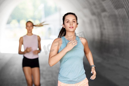 健身、运动和健康的生活方式理念--年轻女性或女性朋友在户外跑步。年轻女性或女性朋友在户外跑步