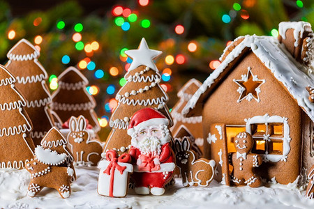 姜饼屋，圣诞冷杉树，圣诞老人和礼物饼干，庆祝寒假概念。姜饼屋和树