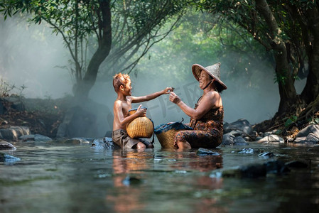 Asaia老太太和小孩在河溪上钓鱼生活在农村的自然生活农民农村/老年妇女祖母和孙子