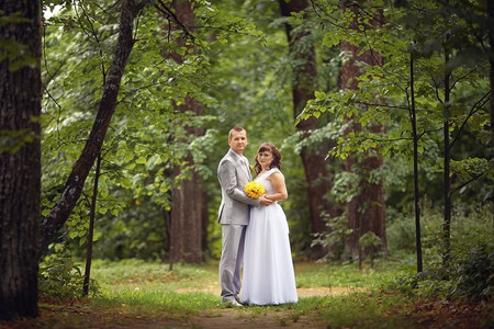 新婚大吉摄影照片_夏天，新娘和新郎在公园里散步