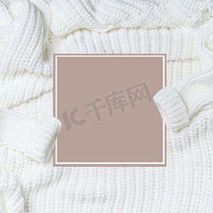 白色针织毛衣袖子和空白卡，顶视图。寒冷的天气季节布局。平躺。为您的设计复制空间。  Instagram风格。现代