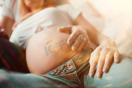 怀孕概念分娩和爱/男人和女人，大肚子，手在心脏的形状，怀孕和爱的象征