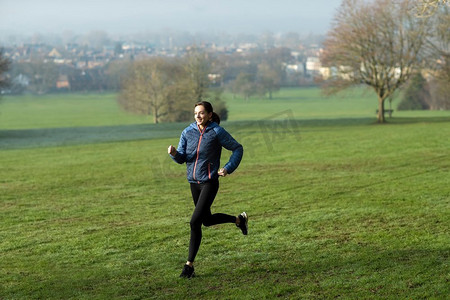 冬日清晨的女人在公园里跑步，通过锻炼保持健康
