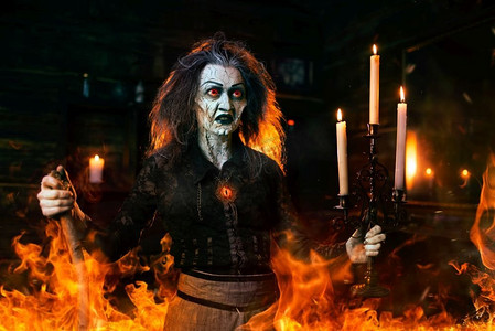 在镜子和蜡烛上拿着拐杖的可怕女巫,巫术的黑暗力量,精神降神会.