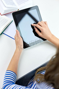 教育、科技和人的观念-女学生在家中使用平板电脑特写。女学生在家中使用平板电脑