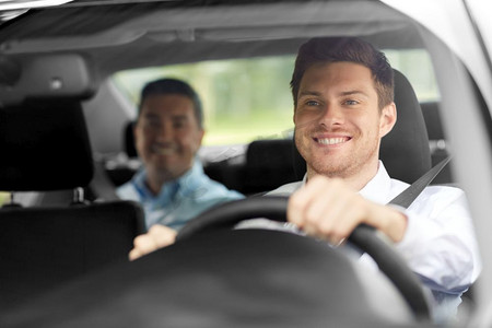 交通、人和出租车概念—快乐的微笑男司机驾驶汽车与乘客。男出租车司机驾驶汽车与乘客