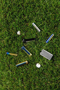 eco摄影照片_循环利用、环境和生态概念—草地上的碱性电池特写。近拍碱性电池在草地上