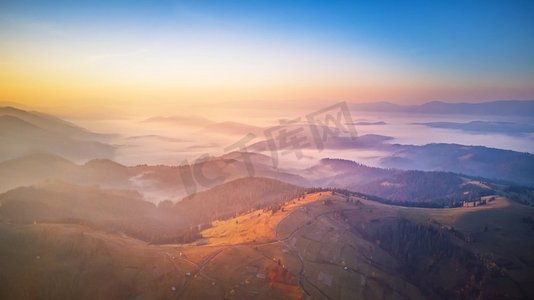 空中全景美丽的秋天山脉。日出在高山雾谷。清晨的迷雾森林。喀尔巴阡山