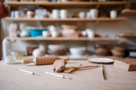 陶器摄影照片_车间的木桌上摆放着设备，没人。手工制粘土餐具成型和成型，传统爱好，器皿制作