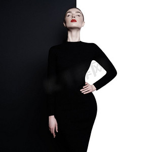 时尚艺术工作室象在几何黑白背景的优雅的妇女。用红色唇膏专业化妆。时尚的经典连衣裙。