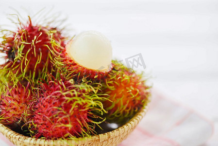 红毛丹在餐桌上的篮子里剥皮背景/泰国花园里新鲜的红毛丹夏季水果