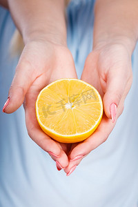 美味水果柠檬摄影照片_健康的饮食，清爽的食物富含维生素。女人拿着甜蜜美味的柑橘水果，柠檬在橙子。妇女拿着水果柠檬或橙子