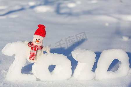 漂亮的雪人在下雪的新年2020日期背景