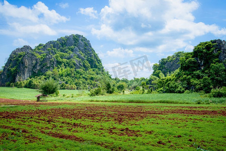 有犁的风景农村领域农民种植和岩石山蓝天背景/开始耕作玉米领域