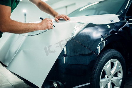 汽车喷漆保护膜安装工艺。工人的手准备保护涂层，防止碎屑和划痕