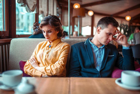 坏心情摄影照片_一对夫妇心情不好坐在餐厅里。男女关系。夫妇在一个坏心情坐在餐厅