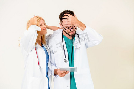 沮丧的外科医生和全科医生在白色背景医疗失败和医疗事故的概念。两个沮丧的医生。医疗失败的概念。